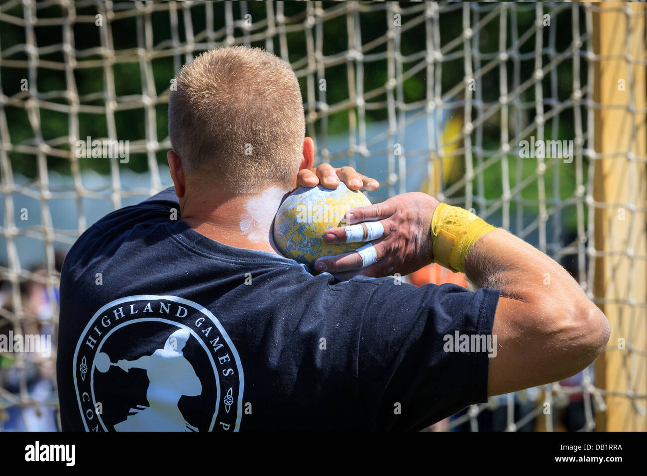 Concorrente detiene il 16 pound sfera nella musica tradizionale scozzese della concorrenza a giochi delle Highland, Loch Lomond, vicino a Glasgow, Foto Stock
