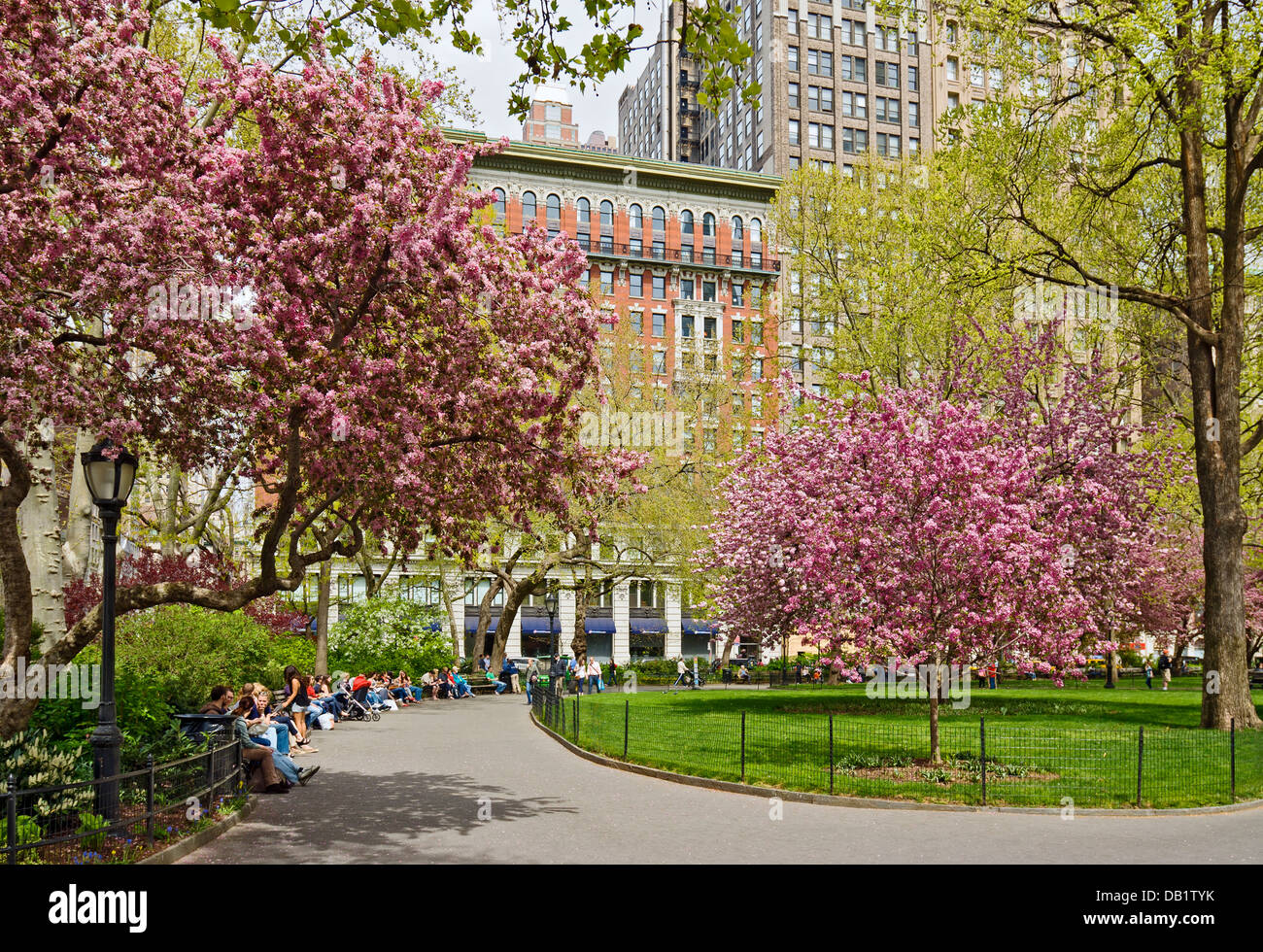Le persone che si siedono sui banchi del Parco godendo di Madison Square Park di New York City in primavera. Foto Stock