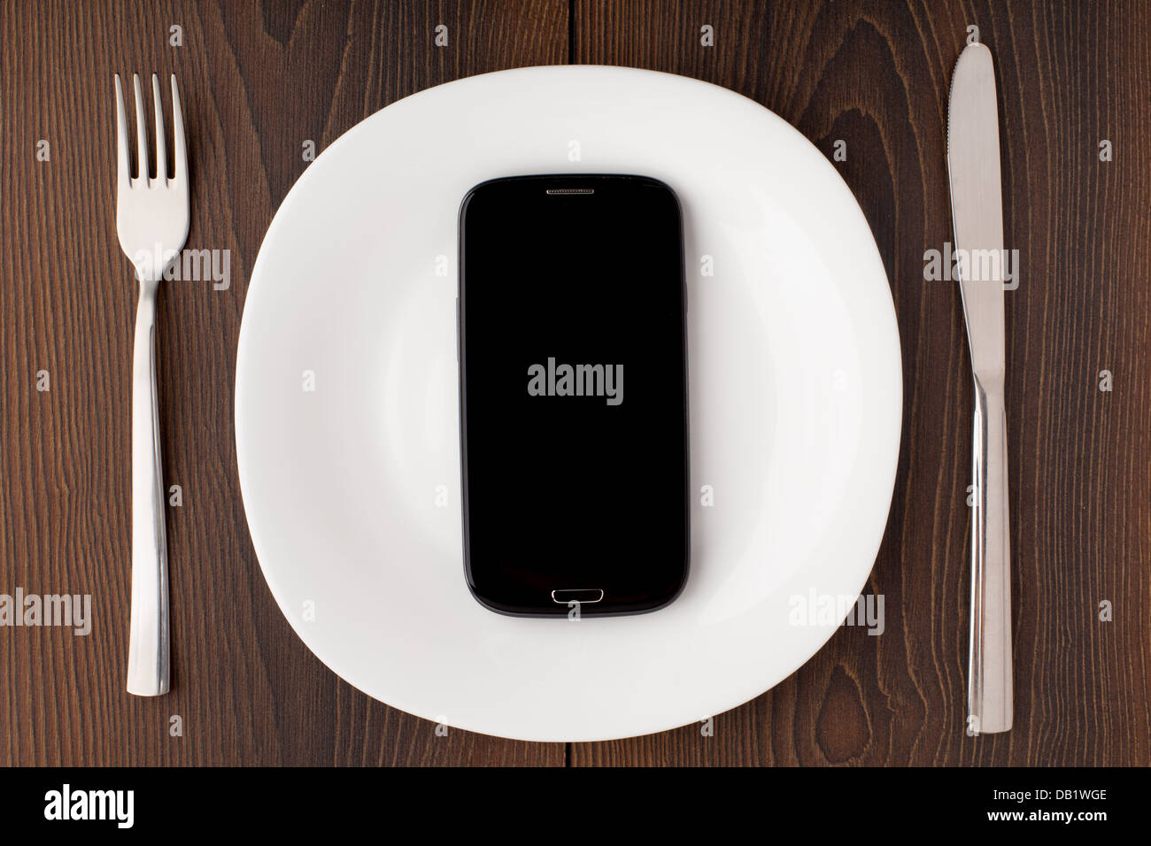 Telefono cellulare su una piastra bianca Foto Stock