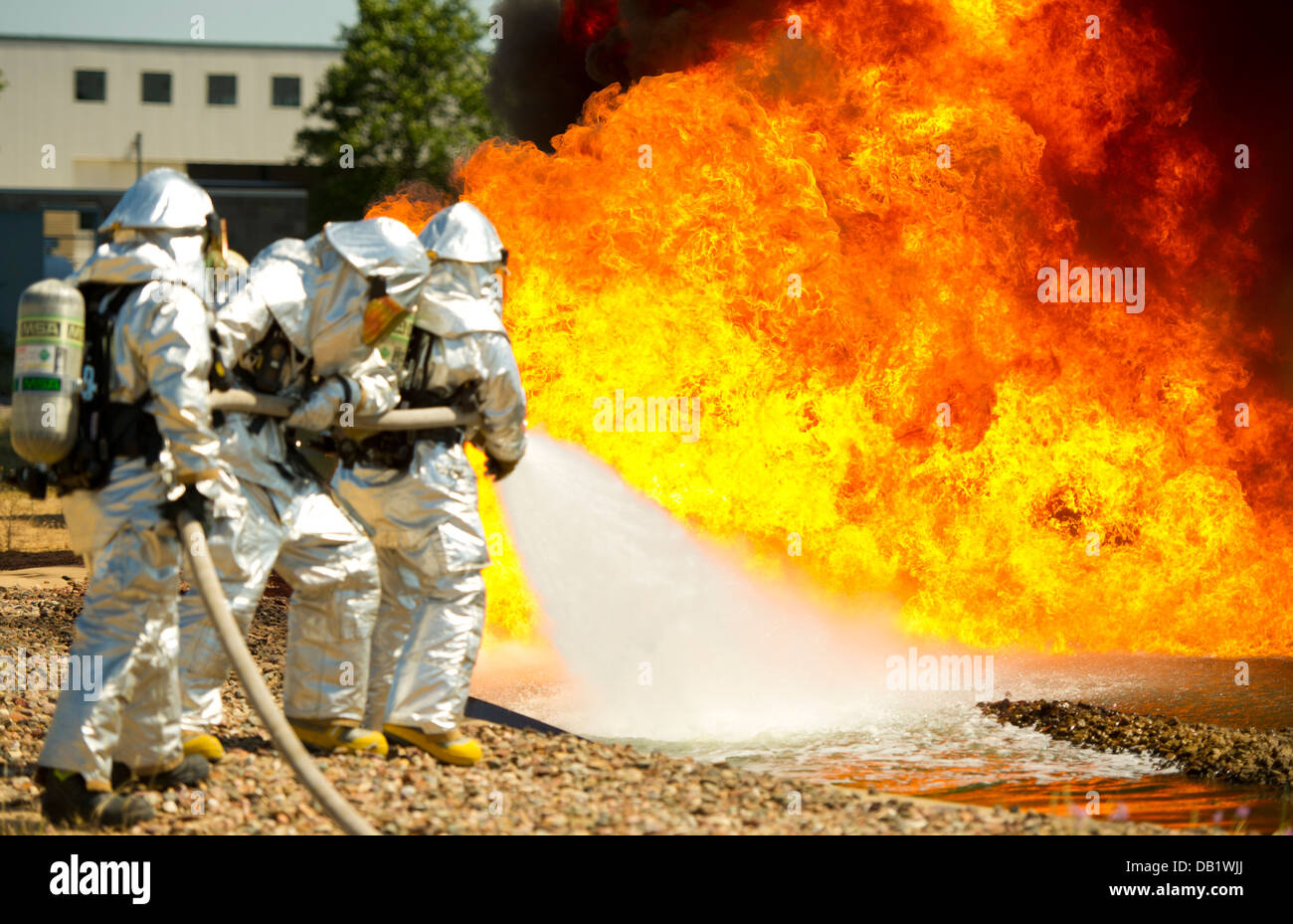 Stati Uniti Air Force vigili del fuoco da sinistra a destra, Senior Airman Joshua Cox, Dustin Lawrence e lo Staff Sgt. Anthony Palestro, estinguere la masterizzazione di propellente a getto 8 carburante durante un'esercitazione a fuoco durante l'esercizio Global Medic, Fort McCoy, Wis., luglio 19, 2013. Foto Stock