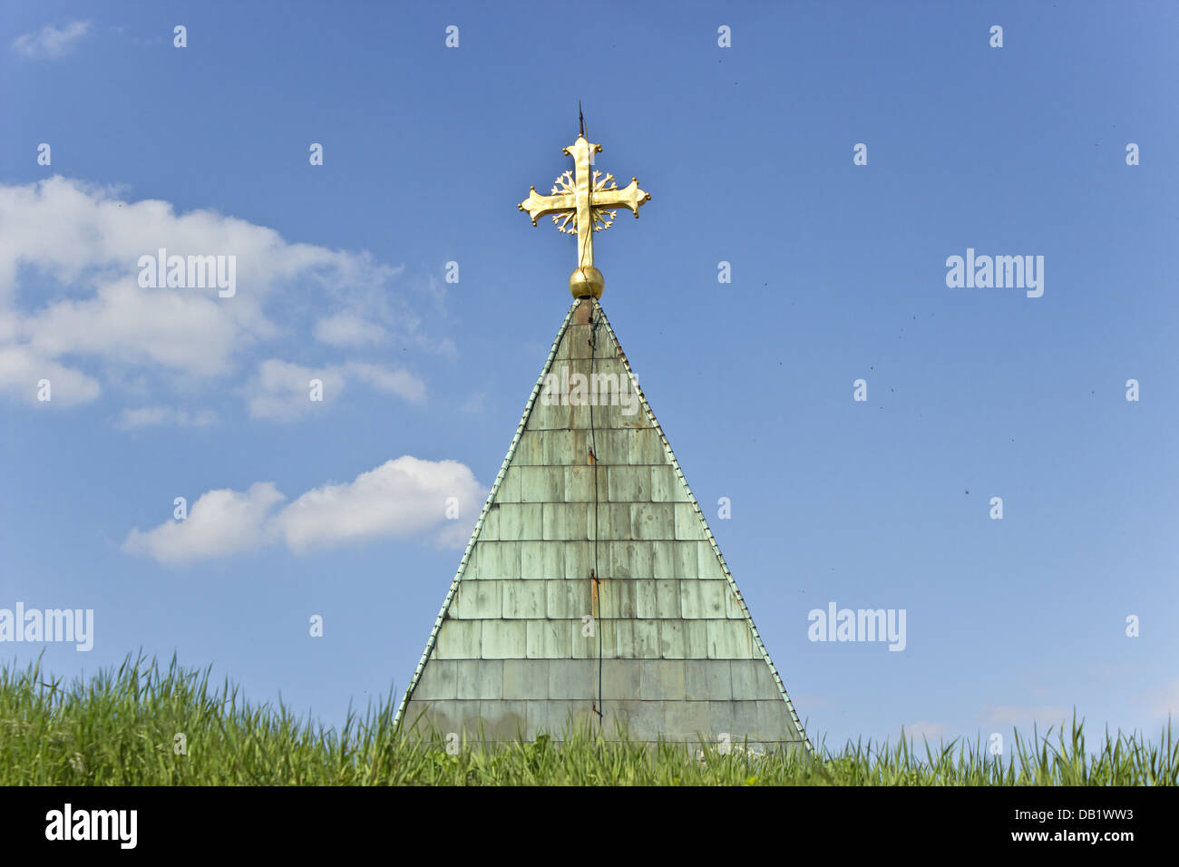 Golden Cross sulla chiesa oltre il cielo blu Foto Stock