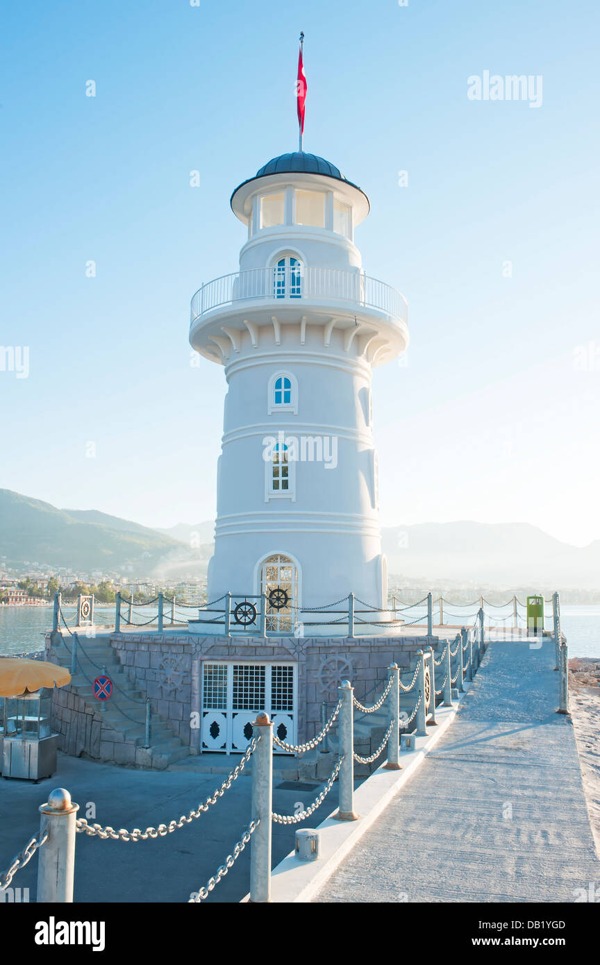 Paesaggio con un faro nella città portuale di Alanya all'alba. Foto Stock