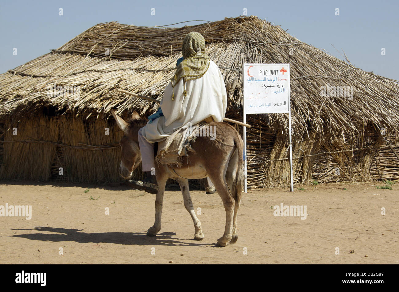 Un agricoltore Sudanes giostre a lunga distanza con il suo bambino malato allo scopo di ottenere un trattamento medico nel villaggio di Buru nel Darfur occidentale, Sudan, 11 dicembre 2007. I medici guidare tutto il modo da Mukjar ai villaggi che sono fino a 100 chilometri di distanza, al fine di curare gli ammalati. La salute pubblica è gestito dalla Croce Rossa tedesca (DRK) e i sudanesi della Mezzaluna Rossa. P Foto Stock