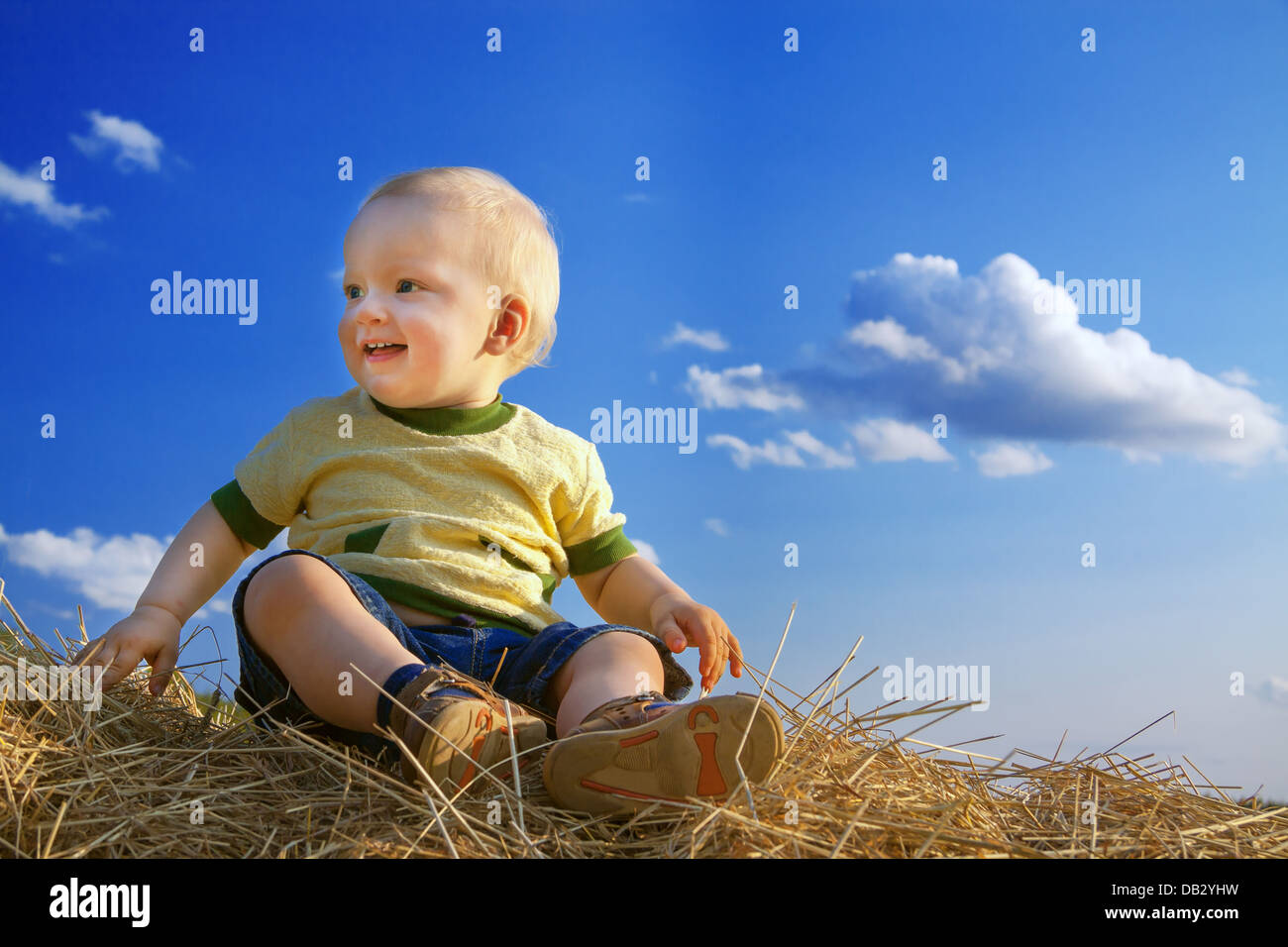 Il piccolo bambino ride contro il cielo blu Foto Stock