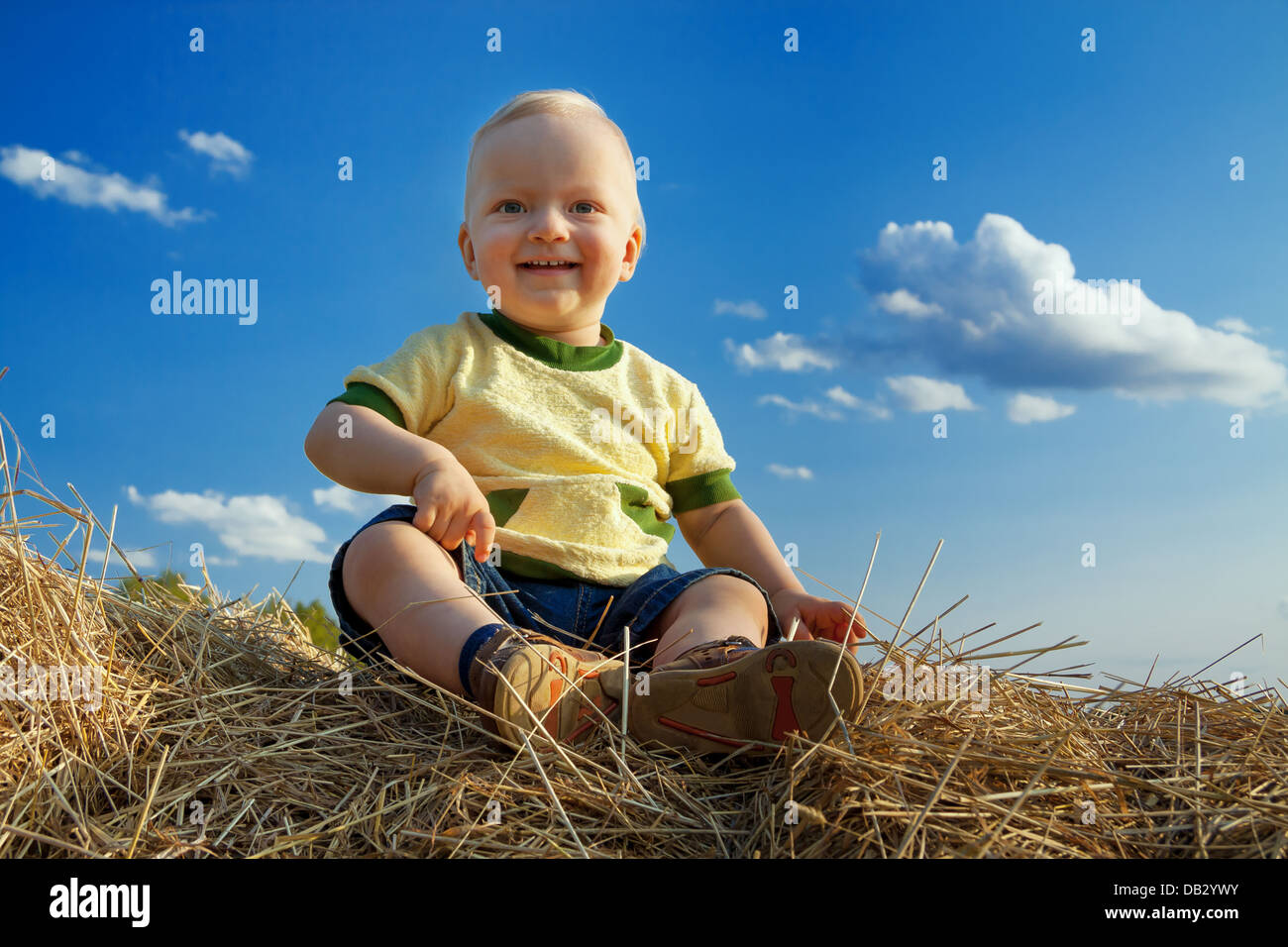 Il piccolo bambino ride contro il cielo blu Foto Stock