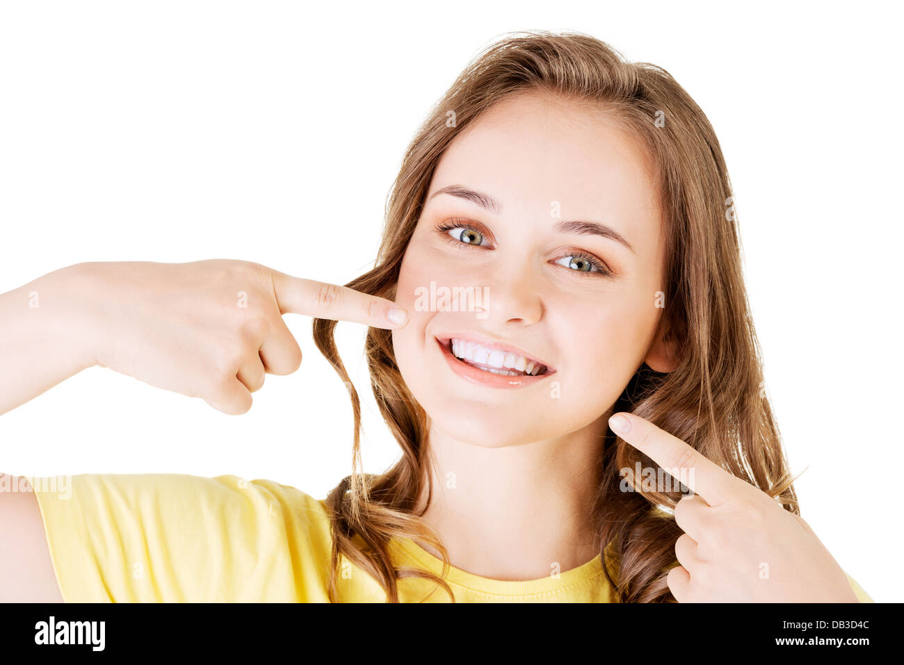 Teen girl puntando sulla sua perfetta denti, isolato su bianco Foto Stock