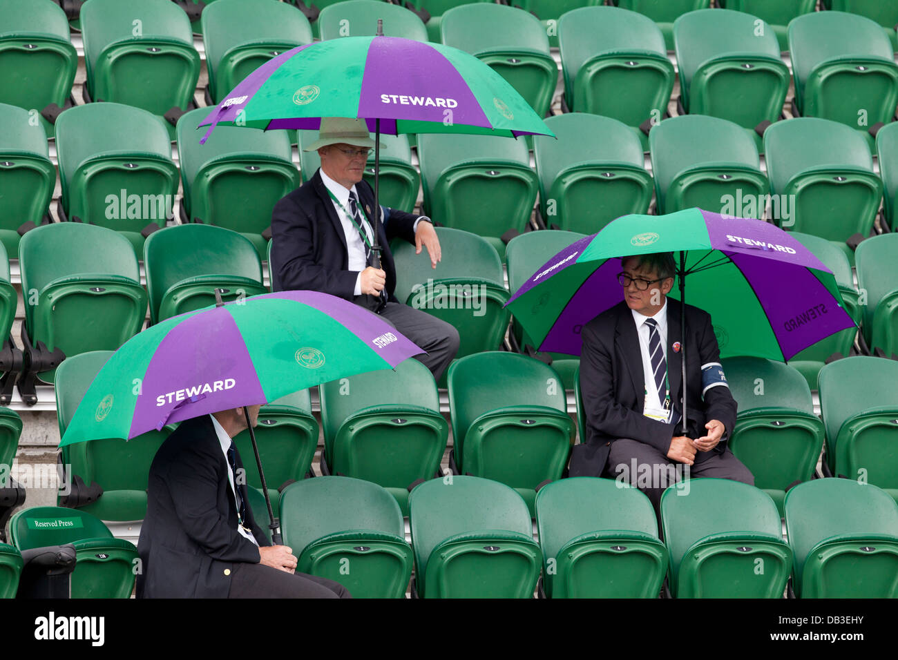 Steward onorario sotto gli ombrelloni sulla Corte n. 2 durante la finale donne i campionati di Wimbledon 2012 All England Lawn Foto Stock