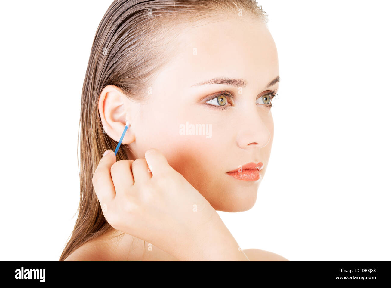 Donna faccia closeup durante la pulizia di un orecchio con un bastoncino di cotone, su bianco. Foto Stock