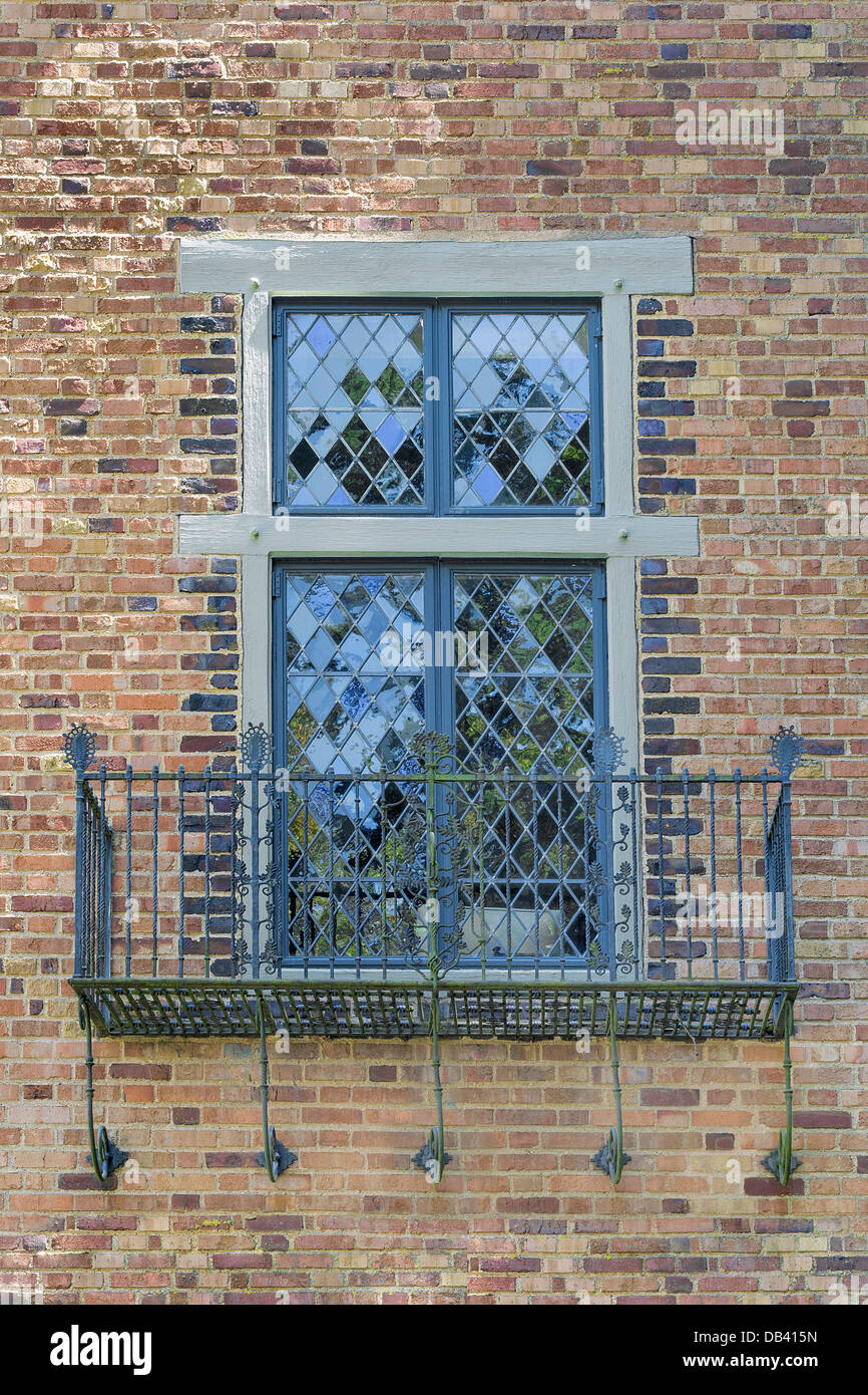 In stile Tudor Windows con asta di ferro metallo Scrollwork balcone sul lato esterno della parete di mattoni Foto Stock
