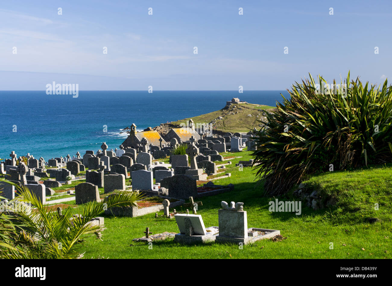 Una vista di St Ives cimitero in una giornata di sole retroilluminato con pietre tombali e mare blu in background. Foto Stock