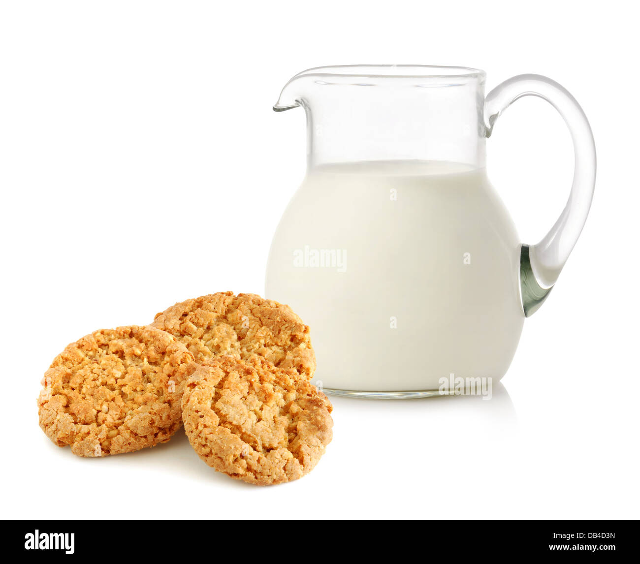 Caraffa di vetro con latte e biscotti su sfondo bianco Foto Stock
