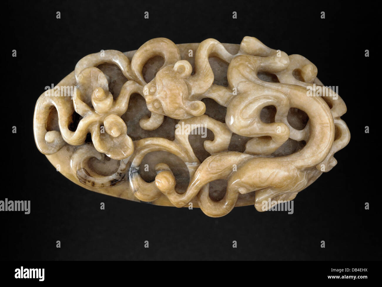 Una placca ovale decorativa con intricate incisioni di un drago e pergamene ruyi, simboli del potere e della fortuna nella cultura cinese. La placca mostra la raffinata maestria artigianale del periodo, con attenzione ai dettagli nei disegni vorticosi. Foto Stock