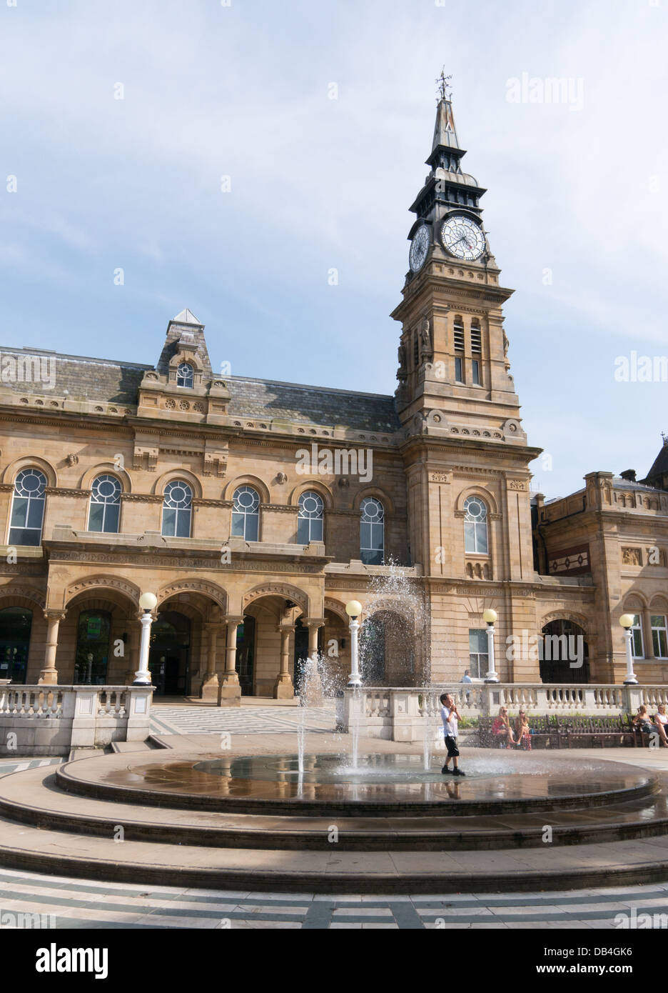 Giovane ragazzo non si raffredda in fontana nella parte anteriore di Southport municipio durante la canicola estiva, North West England, Regno Unito Foto Stock