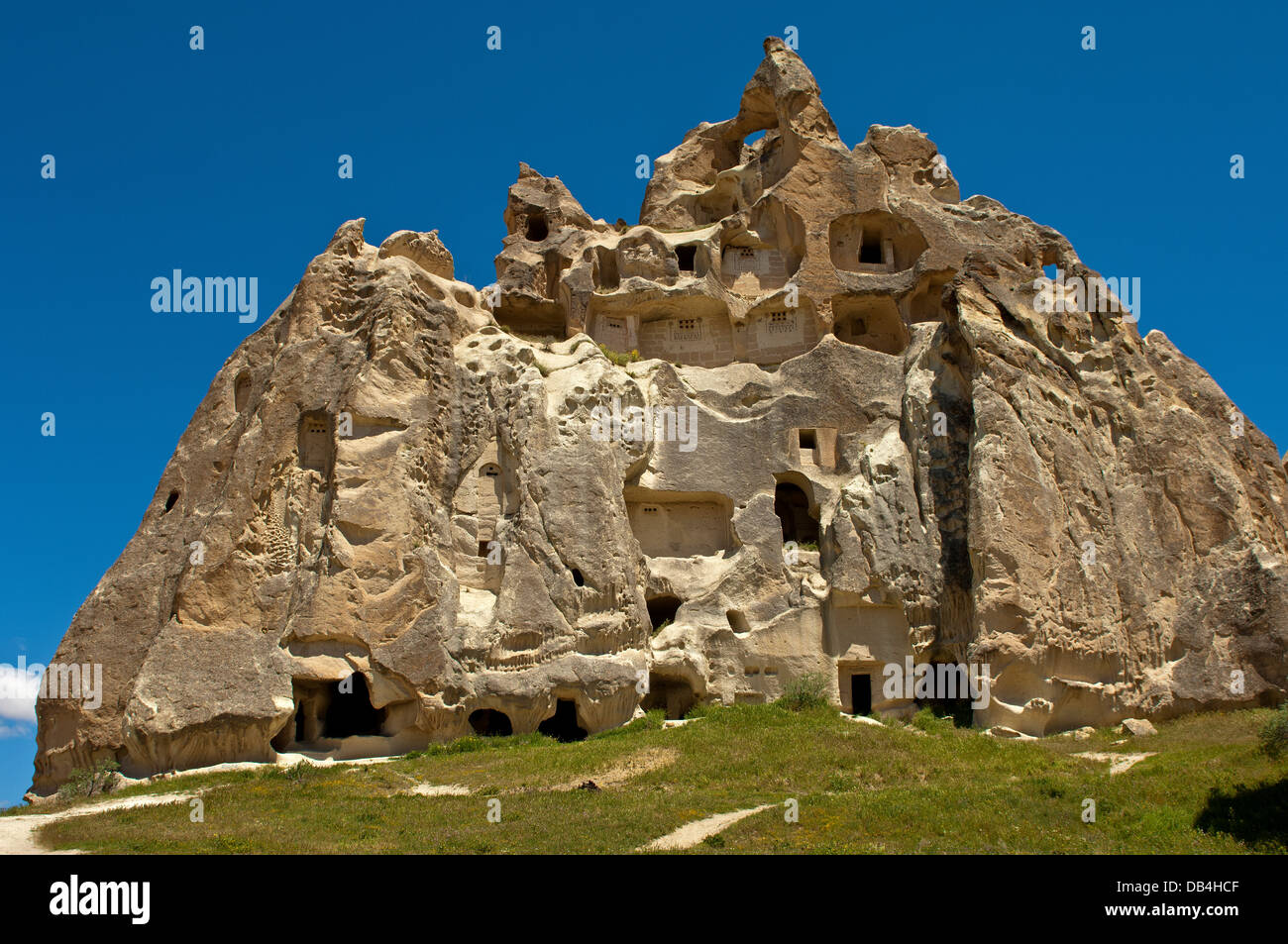 Scavati in fortezza rocce di tufo con camere di stoccaggio, Cavusin, Cappadocia, Turchia Foto Stock