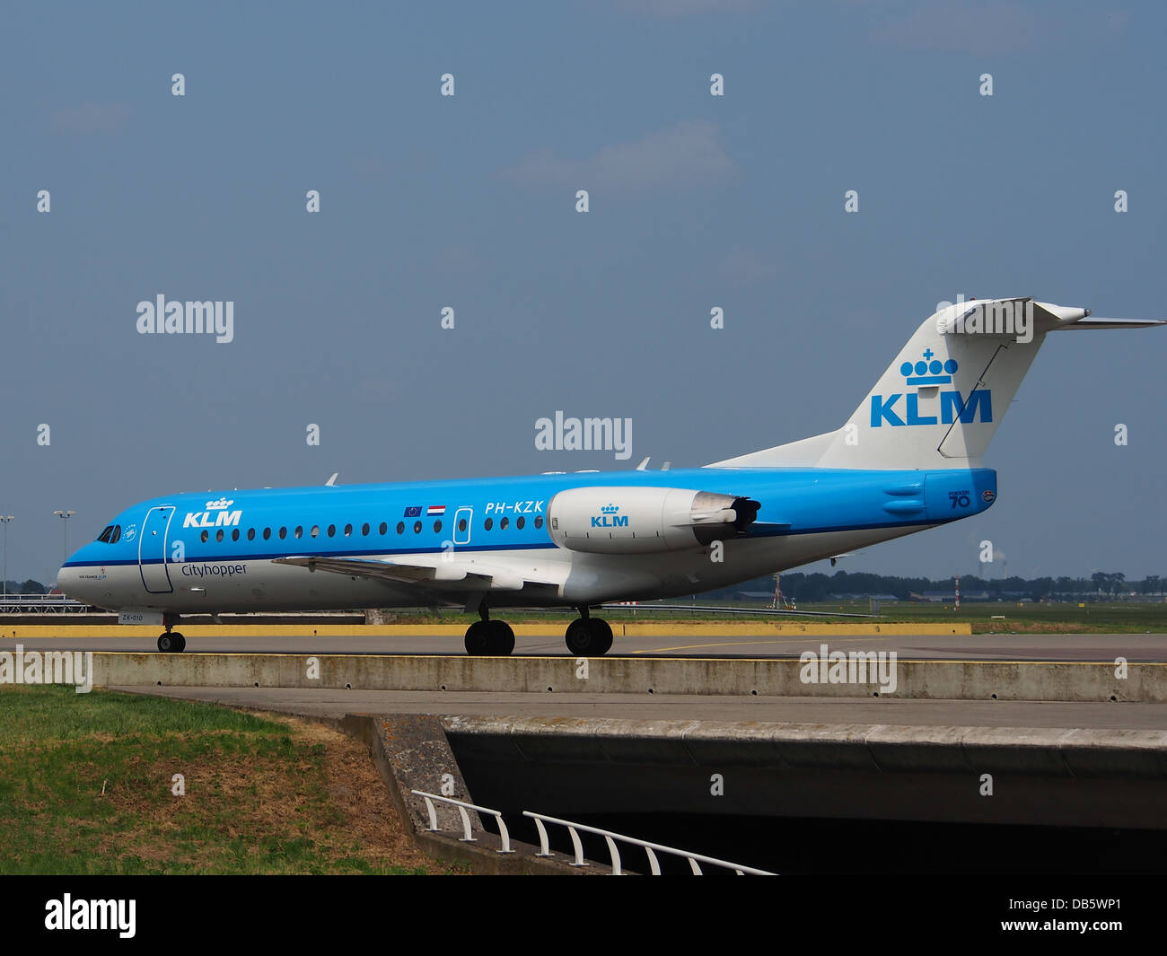 Il Fokker F70, un aereo di linea regionale gestito da KLM Cityhopper, è visto in una posizione di parcheggio in un aeroporto. L'aereo è noto per le sue piccole dimensioni e per l'efficiente funzionamento su brevi rotte regionali, offrendo ai passeggeri comodi posti a sedere. Foto Stock