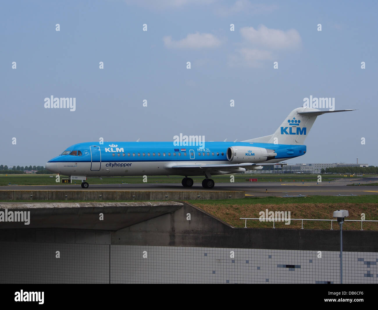 IL PH-KZL è un Fokker F70 operato da KLM Cityhopper, parte della flotta regionale di KLM. Questo aereo è comunemente utilizzato per voli brevi in Europa, offrendo ai passeggeri un'esperienza di viaggio efficiente e confortevole. È visibile qui all'aeroporto Schiphol di Amsterdam. Foto Stock