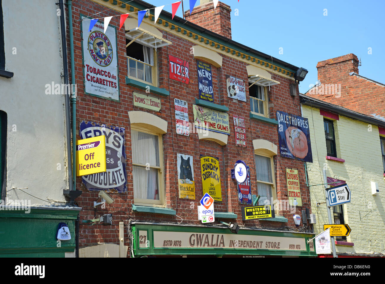 Smalto retrò lo stagno metallico cartelli pubblicitari sulla parte anteriore del negozio, Broad Street, Ross-on-Wye, Herefordshire, England, Regno Unito Foto Stock