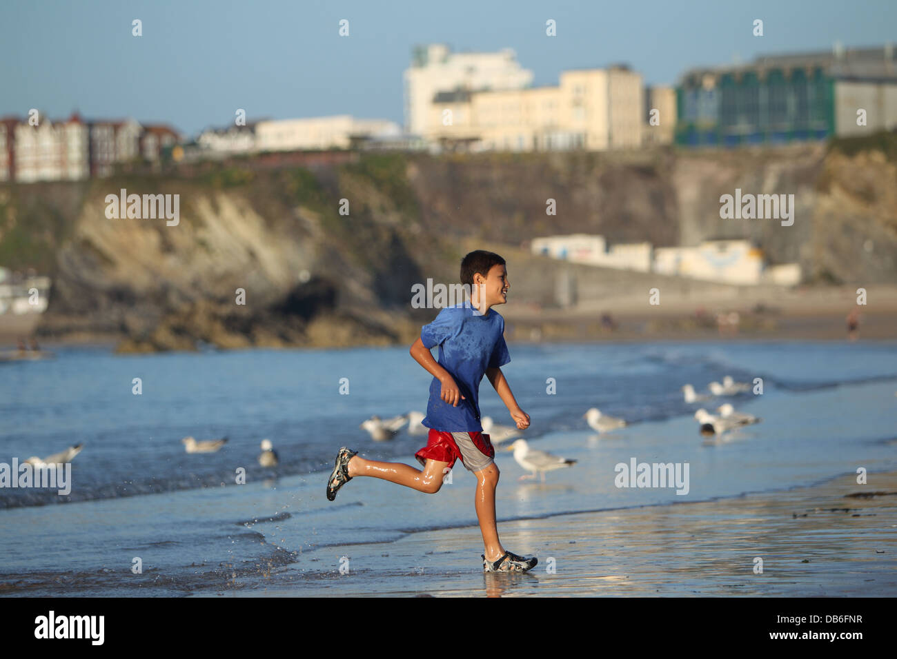 Giovane Ragazzo Gioca E Corre Nel Surf Lungo Una Spiaggia