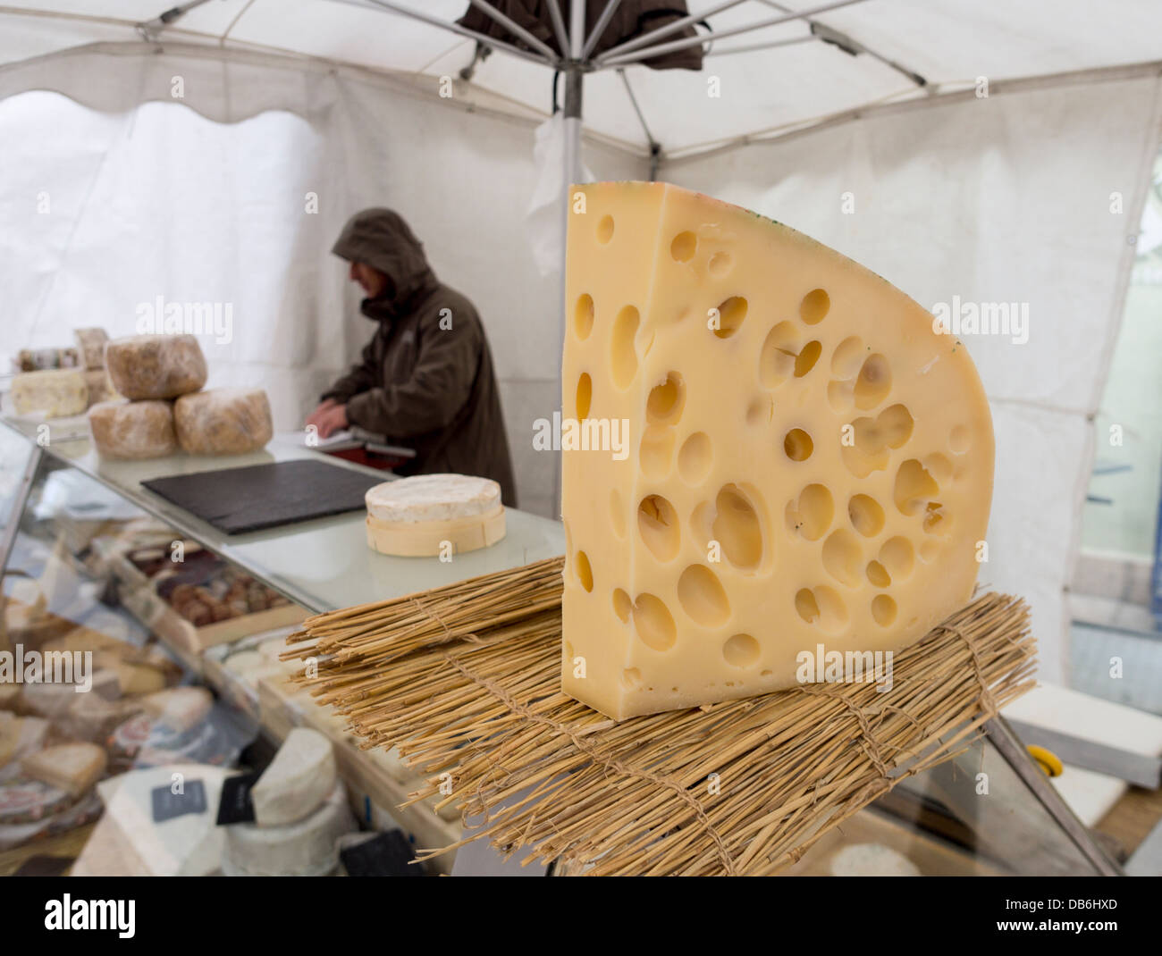 Formaggio Grande con fori. Un grande pezzo di Emmental-style, emmental o formaggio svizzero si siede su un formaggio del fornitore di contatore. Foto Stock