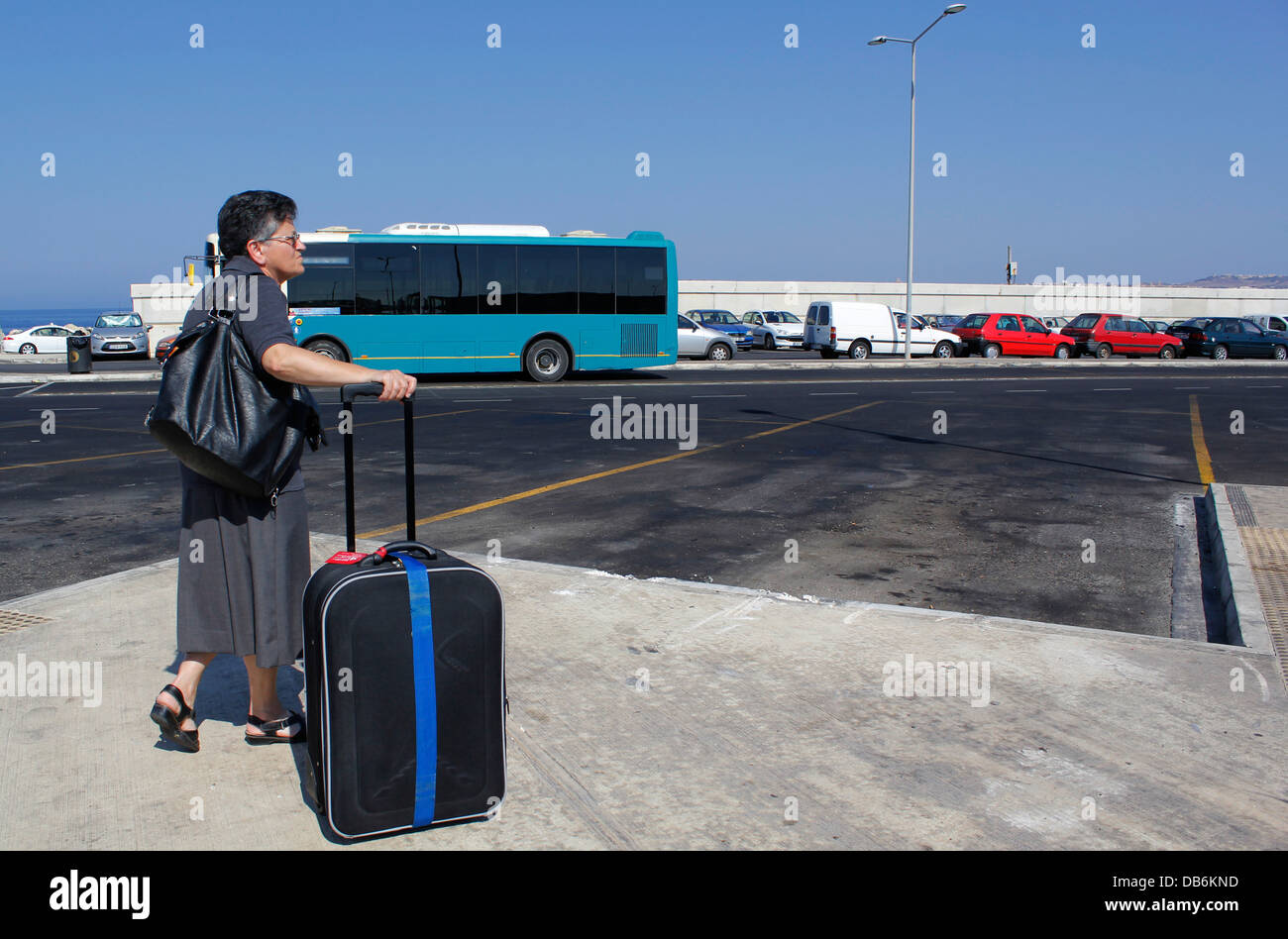 Un passeggero in attesa di un autobus a Cirkewwa Ferry Terminal nell'isola di Malta Foto Stock