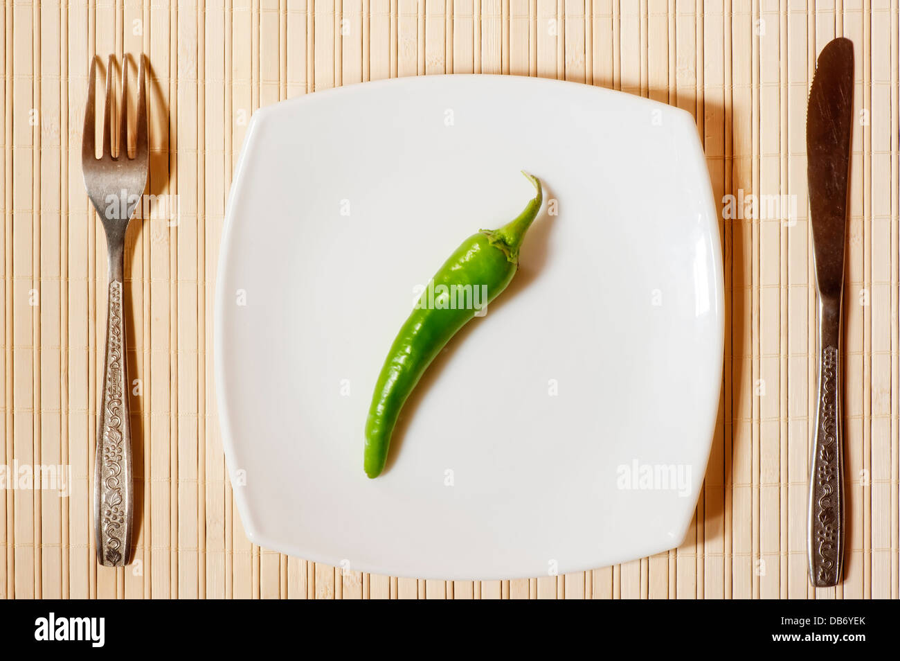 Fresco pepe verde su un quadrato bianco piastra. Foto Stock