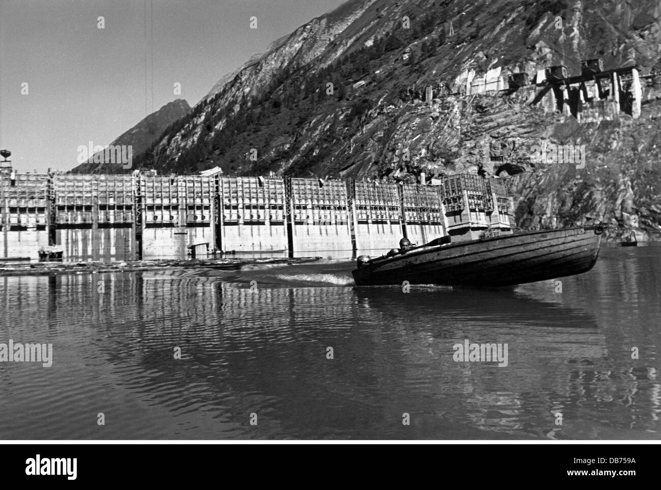 Energia, acqua, diga di Limberg della centrale elettrica di Kaprun durante la costruzione, uomo in barca sul lago di diga, Austria, circa 1950, diritti aggiuntivi-clearences-non disponibile Foto Stock