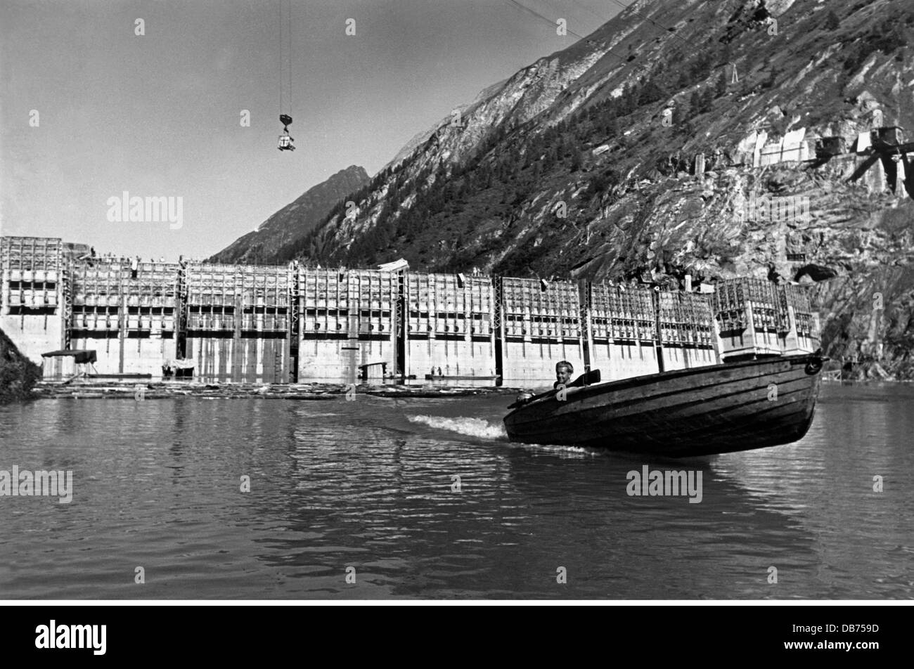 Energia, acqua, diga di Limberg della centrale elettrica di Kaprun durante la costruzione, uomo in barca sul lago di diga, Austria, circa 1950, diritti aggiuntivi-clearences-non disponibile Foto Stock