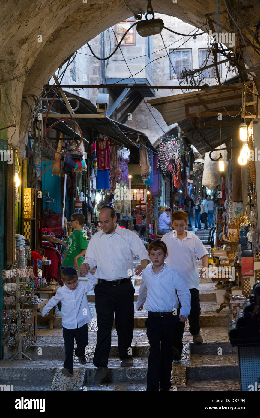 Famiglia ebraica a piedi attraverso il mercato del turismo. Il quartiere musulmano. Gerusalemme la città vecchia. Israele. Foto Stock