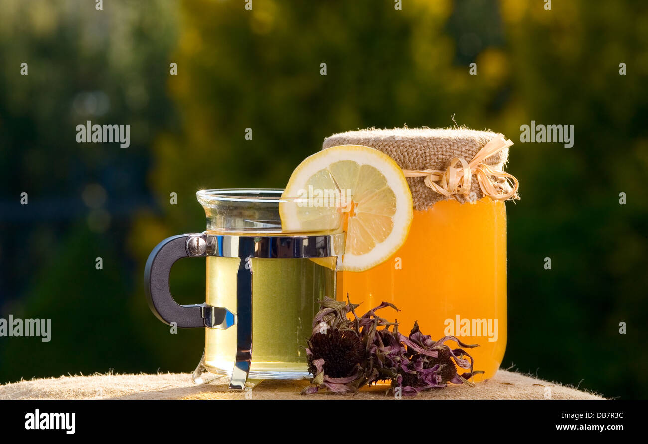 Il tè con il limone nei pressi di un vasetto di miele Foto Stock