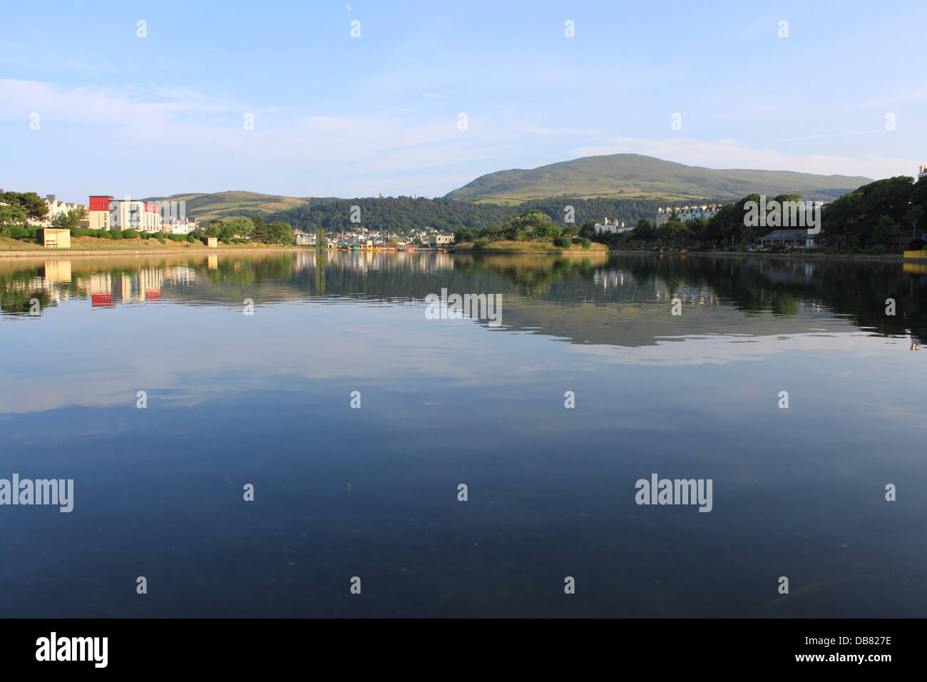 Mooragh Park, Ramsey, Isola di Man, Regno Unito: cielo blu e verdi colline si riflette in un tranquillo lago. Foto Stock