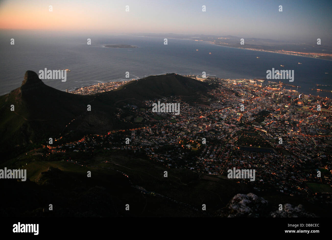 Notte Tempo in Cape Town City Lights Visualizzati top Table Mountain Lions Head Table Bay Robben Island in background. Foto Stock