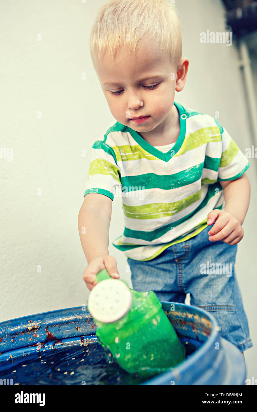 Little Boy suonare con strumenti giocattolo in cortile Foto Stock