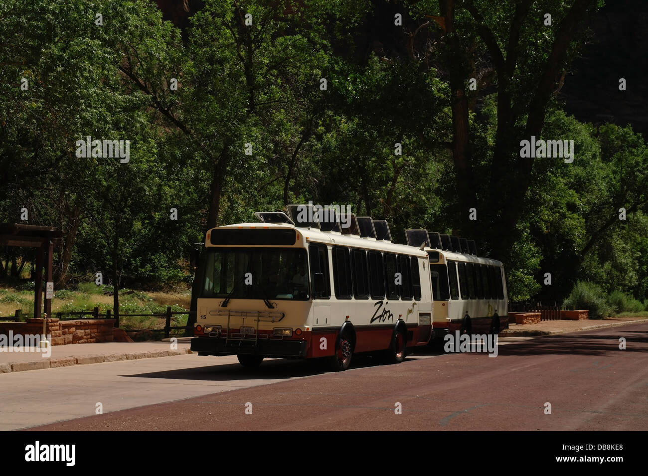 Rosso Bianco Visitor Centre shuttle bus parcheggiato sotto alti alberi verdi, Scenic Drive, Tempio di Sinawava, Zion Canyon dello Utah, Stati Uniti d'America Foto Stock