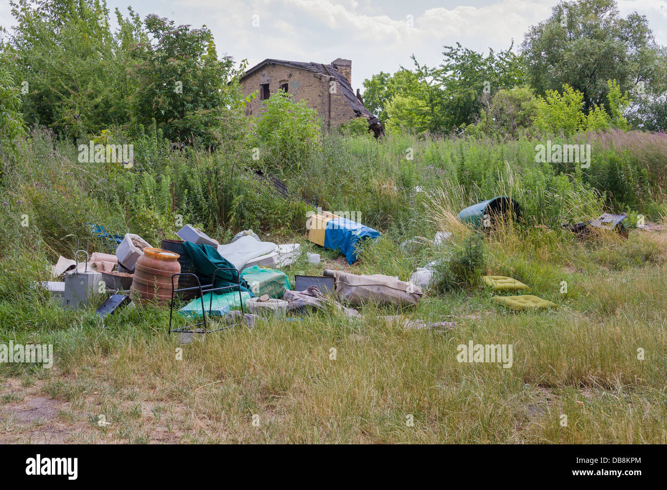 Illegale di discarica di rifiuti in corrispondenza del bordo di un campo Foto Stock