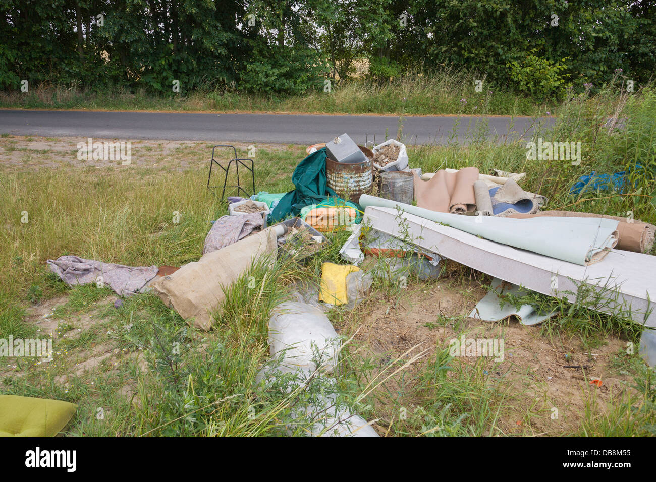 Illegale di discarica di rifiuti in corrispondenza del bordo di un campo Foto Stock