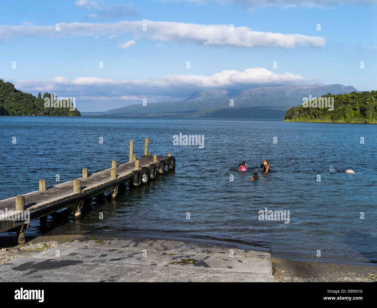 dh Lago Tarawera ROTORUA NUOVA ZELANDA Maori famiglia nuoto lago e Monte Tarawera persone nuotatori Foto Stock