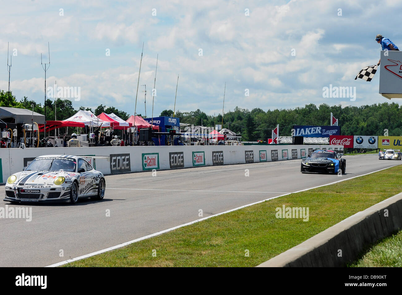 BOWMANVILLE, può., 21 lug 2013 - Il GTC vincitore, n. 22 guidato dal team di Cooper MacNeil e Jeroen Bleekemolen croce sotto la bandiera a scacchi la American Le Mans Racing Mobil 1 SportsCar Grand Prix al Canadian Tire Motorsport Park (precedentemente noto come Mosport Raceway) Foto Stock