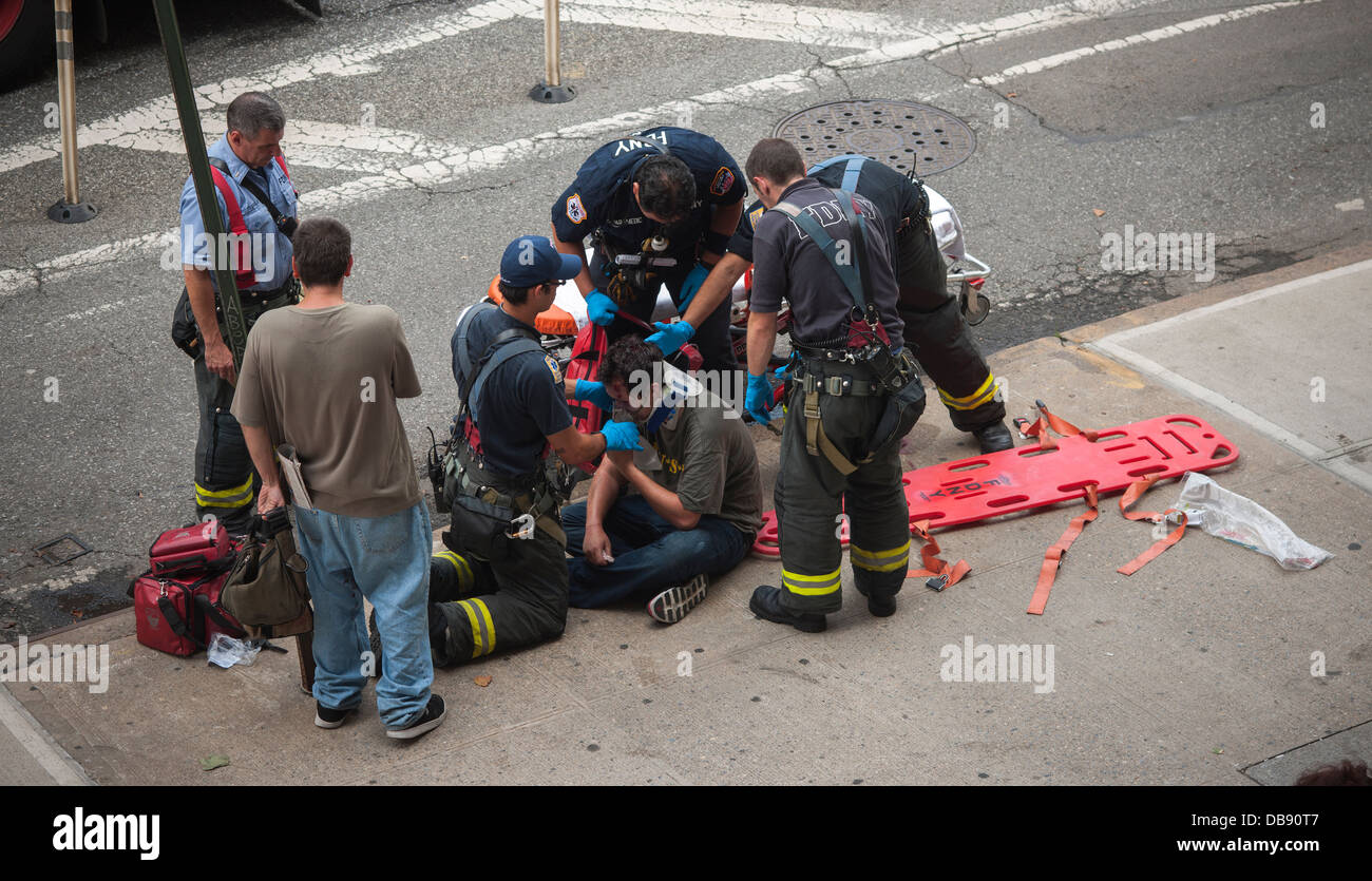 Primi responder stabilizzare e rimuovere la vittima di un incidente nel quartiere di Chelsea di New York Foto Stock