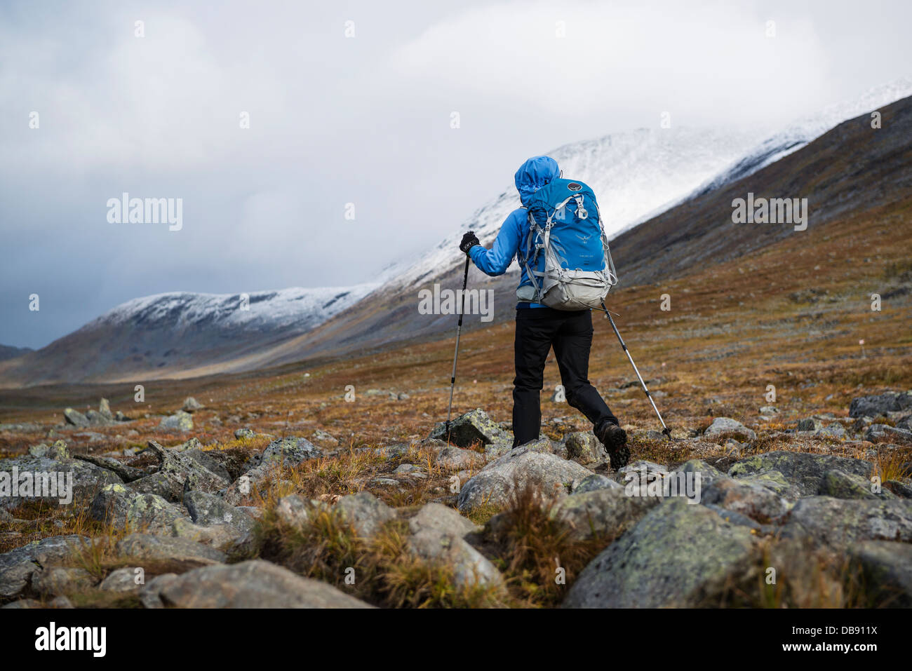 Escursionista femmina escursioni su terreno roccioso in Tjäktjavagge su Kungsleden trail, Lappland, Svezia Foto Stock