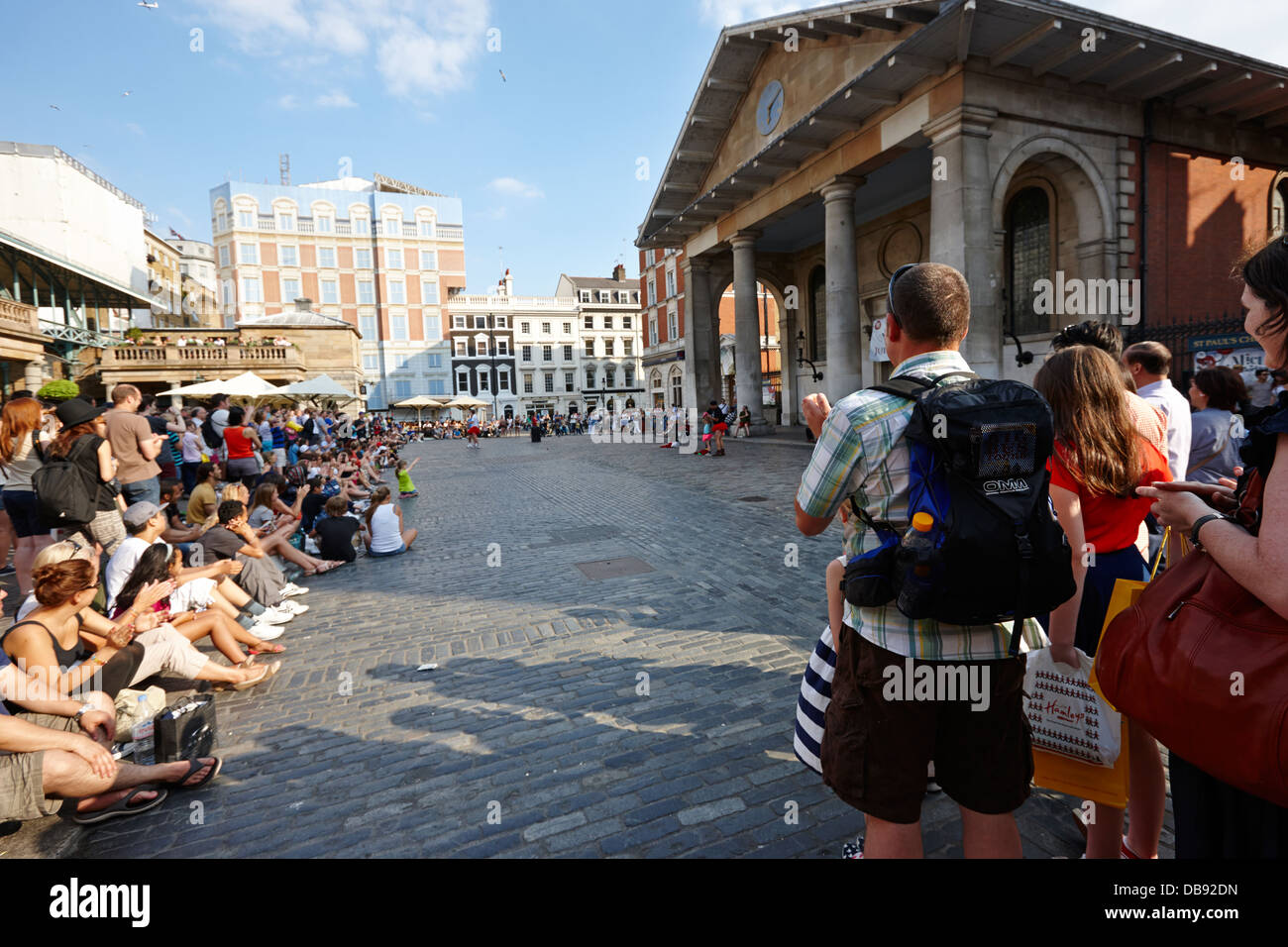 I turisti a guardare gli artisti di strada a Covent Garden Londra Inghilterra REGNO UNITO Foto Stock