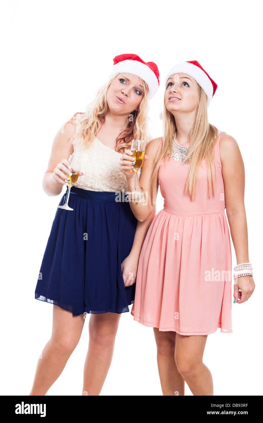 Due donne godendo di festa di Natale con un bicchiere di alcool, isolati su sfondo bianco. Foto Stock Due donne godendo di festa di Natale con un bicchiere di alcool, isolati su sfondo bianco. Foto Stock
