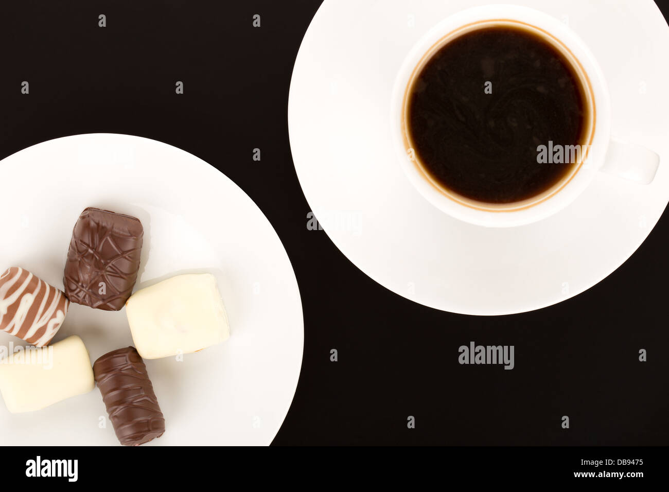 Assortimento di cioccolato in piastra bianca e la tazza di caffè. Foto Stock