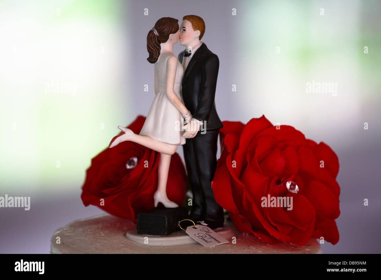 Sposa e lo sposo decorazione sulla parte superiore della torta di nozze con rose Foto Stock