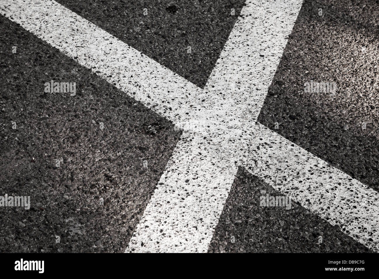 Attraversamento di strada bianca linee su asfalto scuro Foto Stock