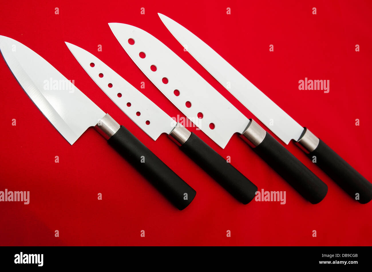 I coltelli di taglio affilati bianco su uno sfondo rosso Foto Stock