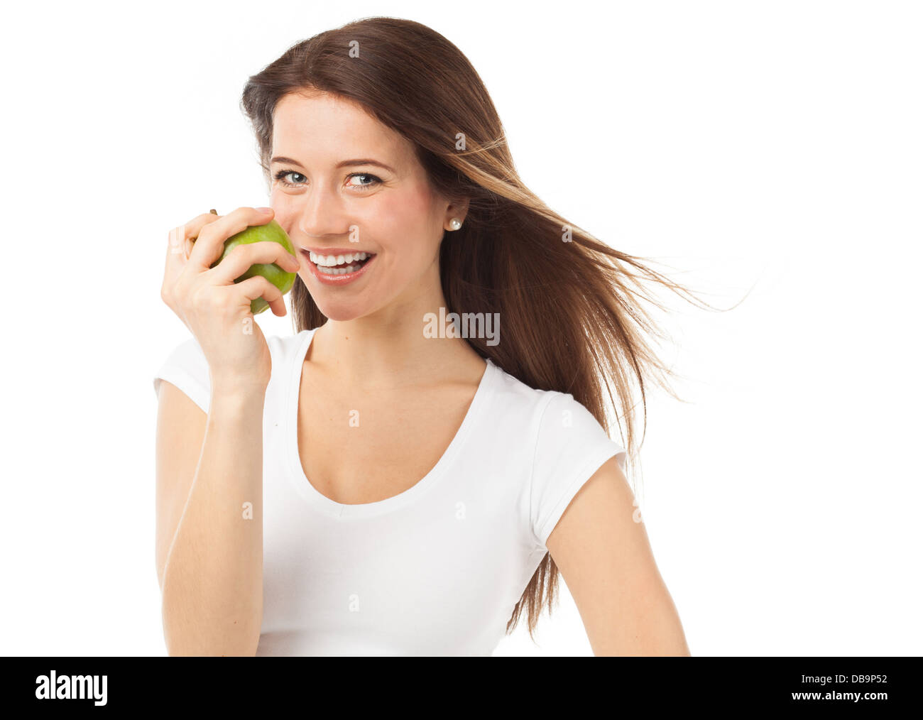 Giovani e allegra donna mangiare una mela verde, isolato su bianco Foto Stock