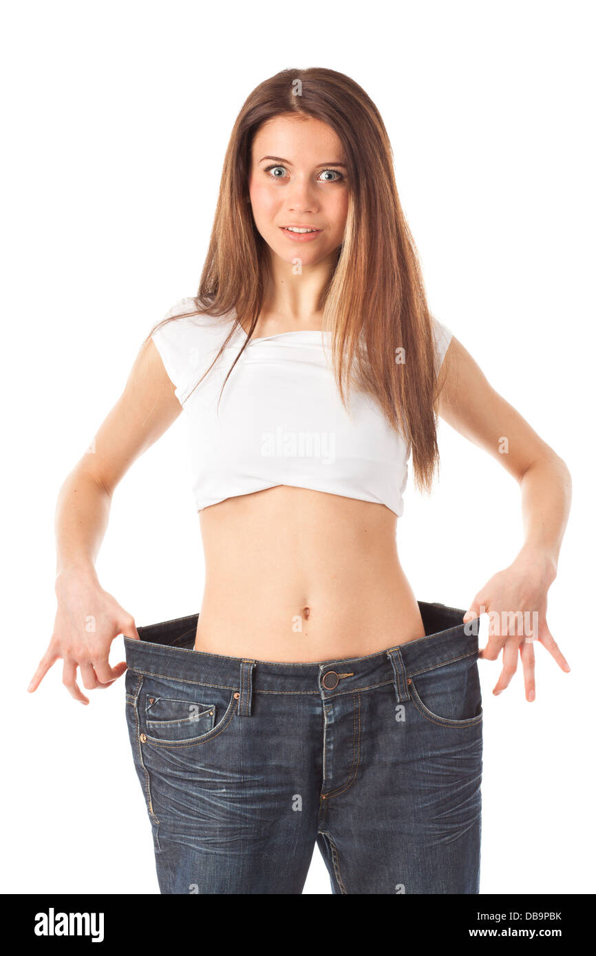 Giovane donna guardando sorpreso che mostra quanto peso ha perso, isolato su bianco Foto Stock