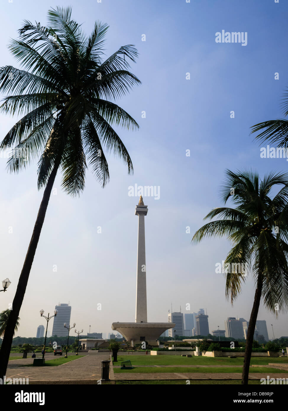 Piazza Merdeka vista sullo skyline di Giacarta e Monumento Nazionale incorniciato da palme di Jakarta, Indonesia: Foto Stock