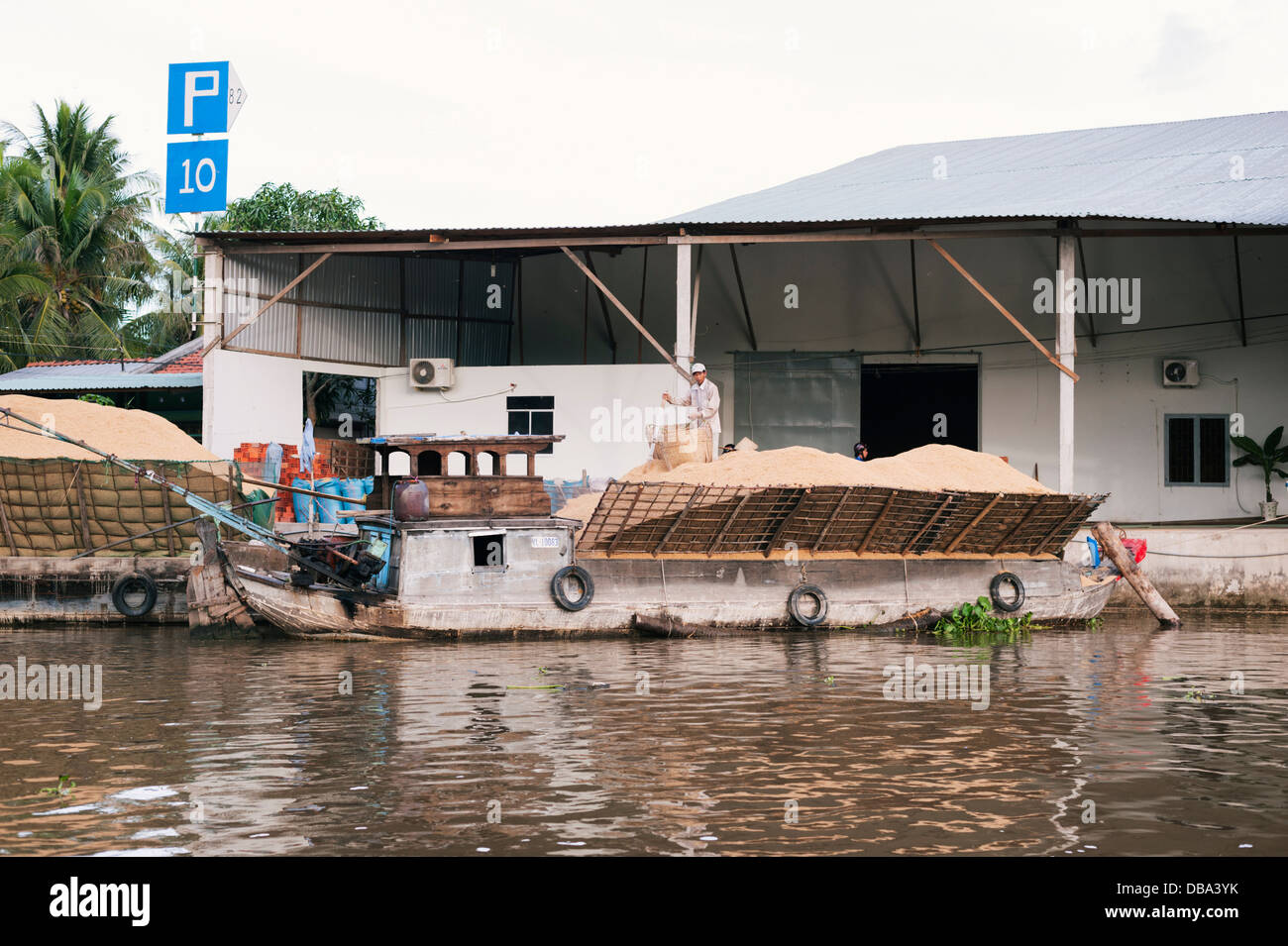 Delta del Mekong, Vietnam - barca caricata di lolla di riso che è bruciato come combustibile. Anche usato come fertilizzante e materiali da costruzione. Foto Stock