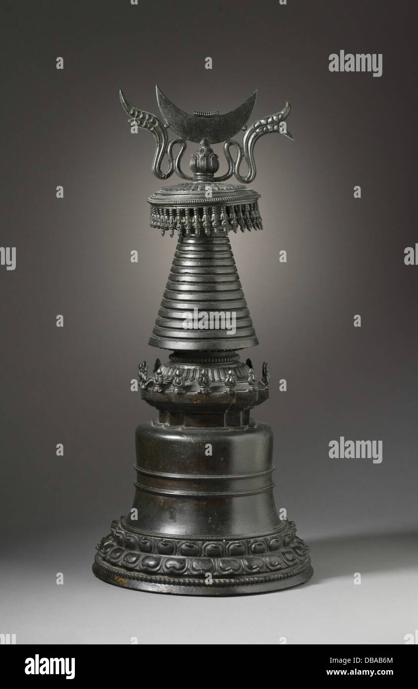 Questo stupa reliquiario, utilizzato nei rituali buddisti, è progettato per ospitare reliquie sacre, in genere i resti di santi o divinità. Realizzato in metallo, è un importante esempio di arte e pratica religiosa buddista, che riflette la riverenza per i resti sacri nella tradizione buddista. Foto Stock